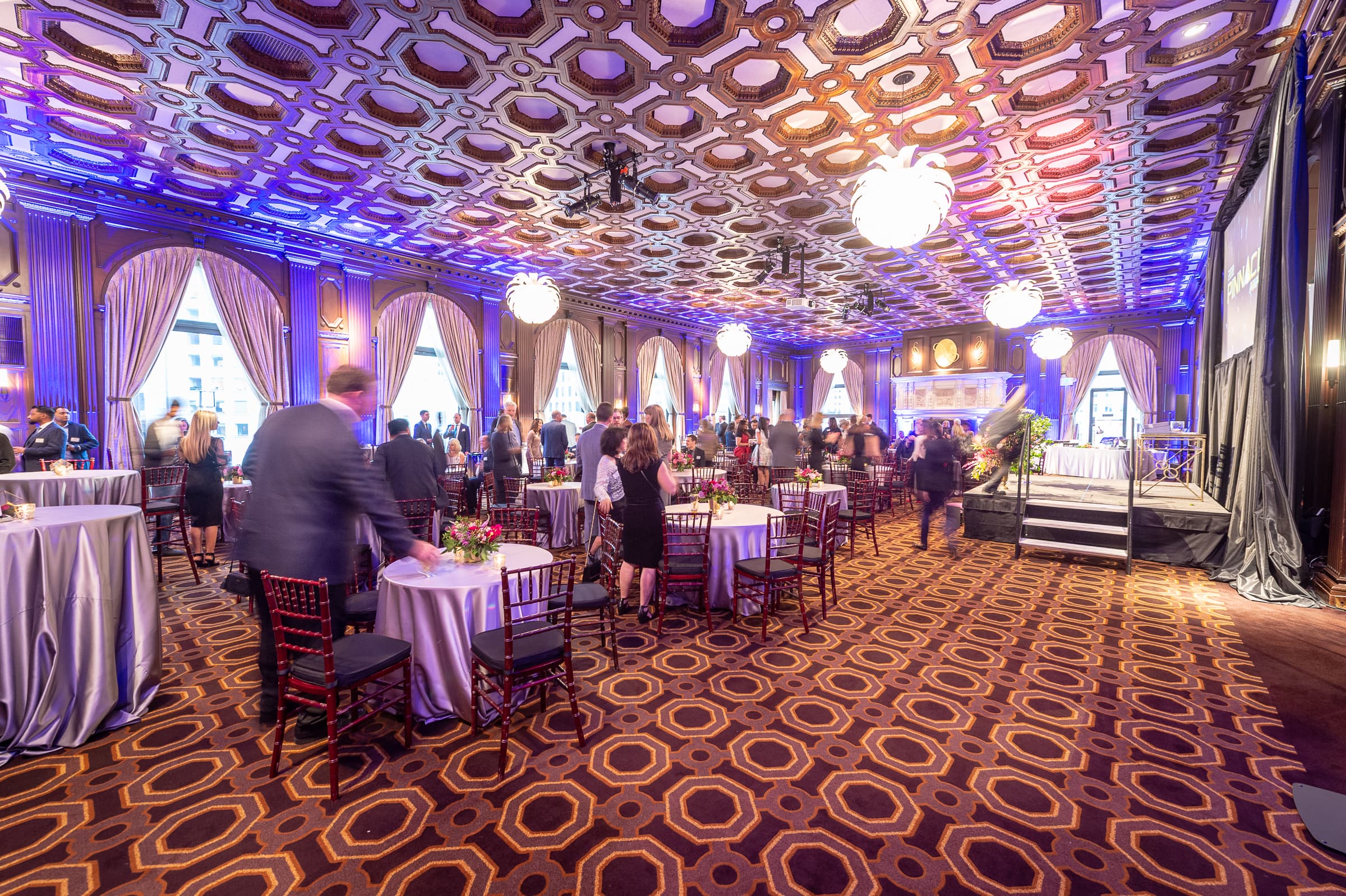 Grand ballroom in purple light as guests take their seats