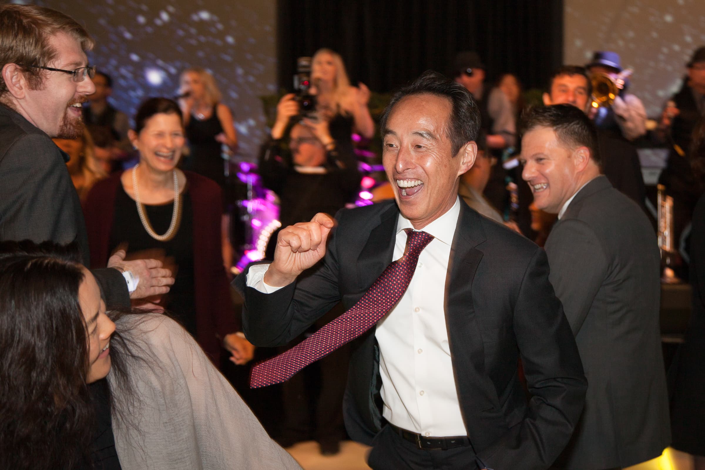 Guest dancing mid-celebration surrounded by colleagues