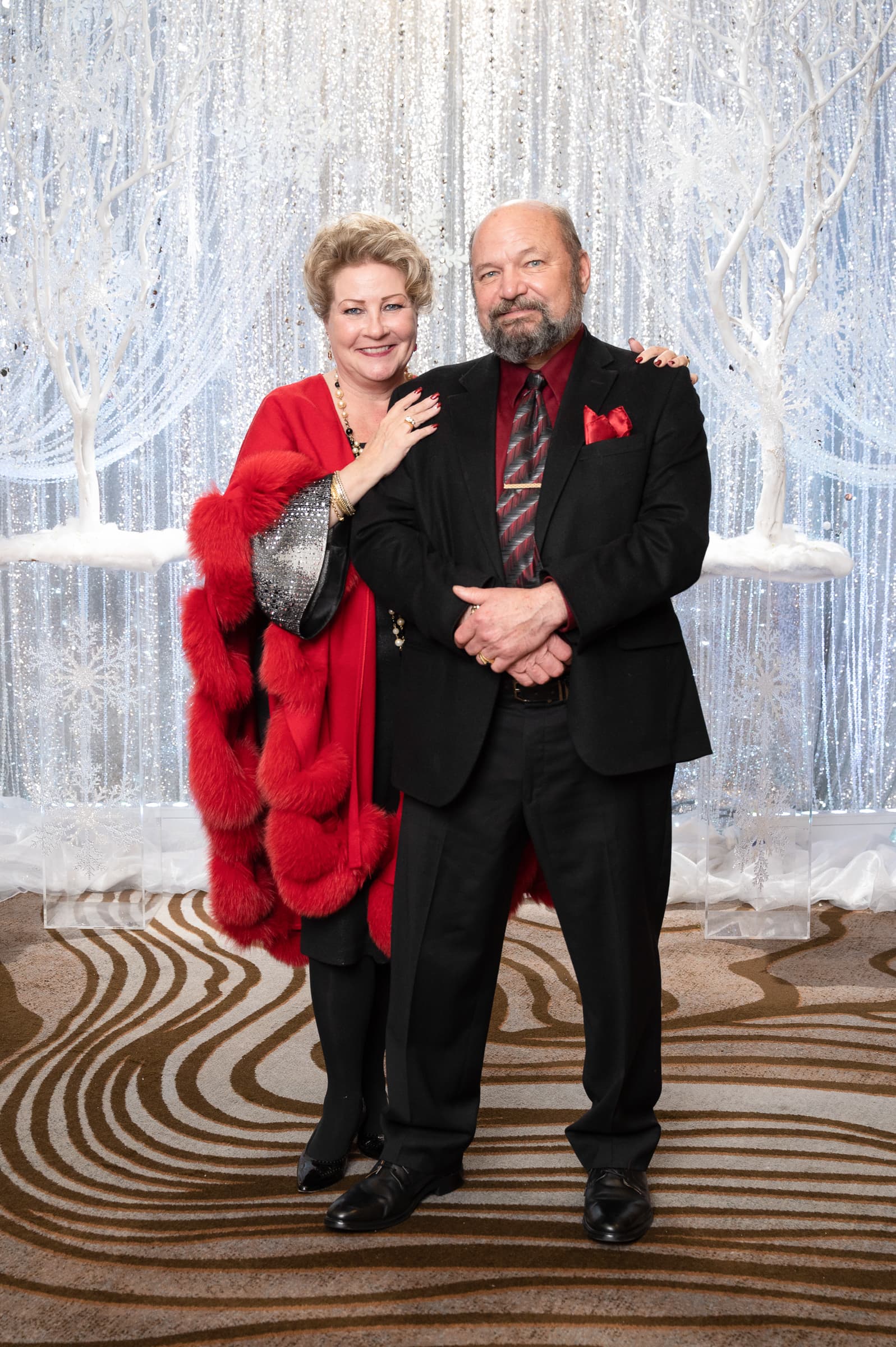 Guests in evening dress photographed against a silver backdrop