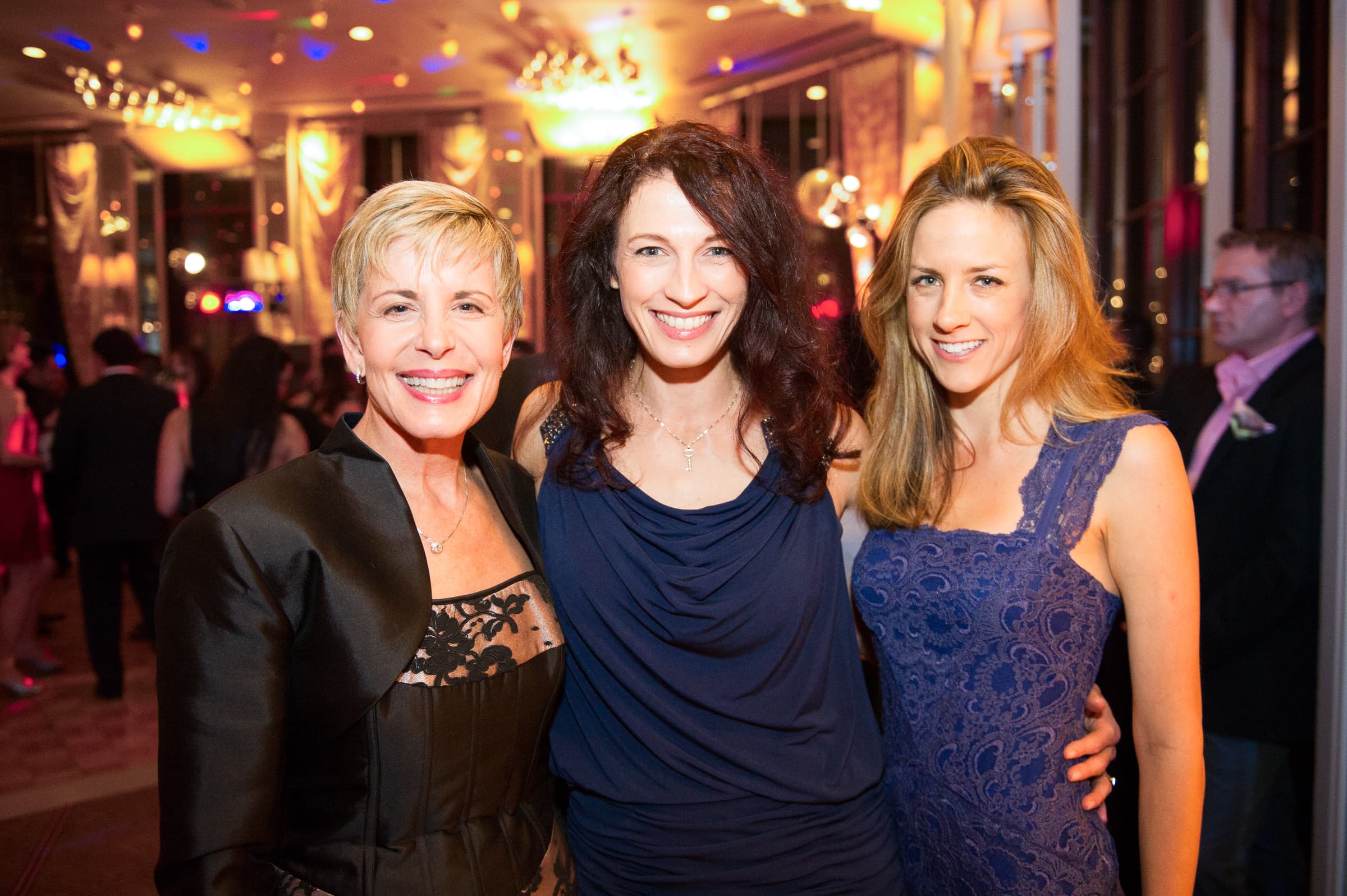 Three guests photographed together during a holiday reception