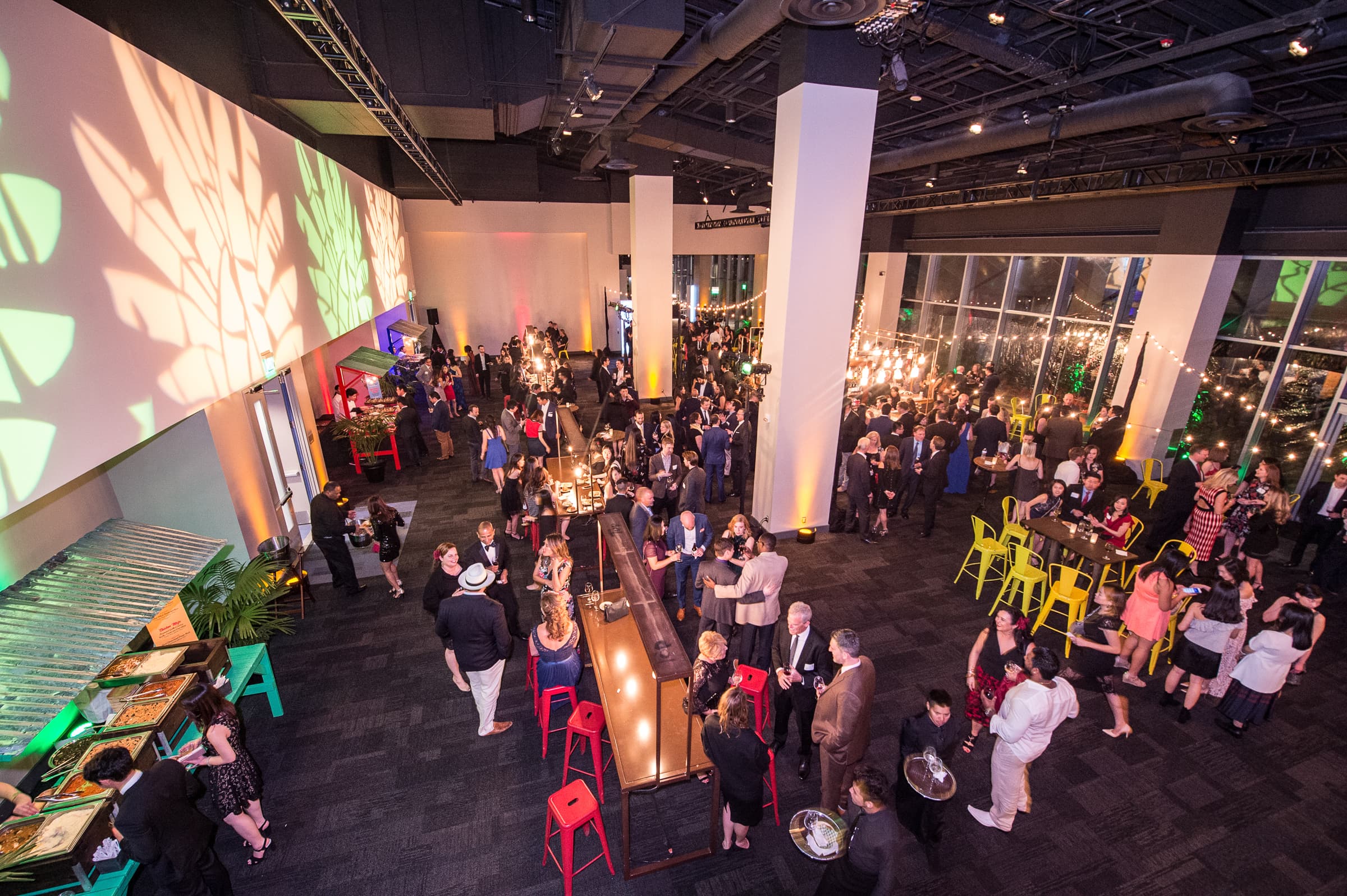 Loft venue filled with guests beneath projected pattern lighting