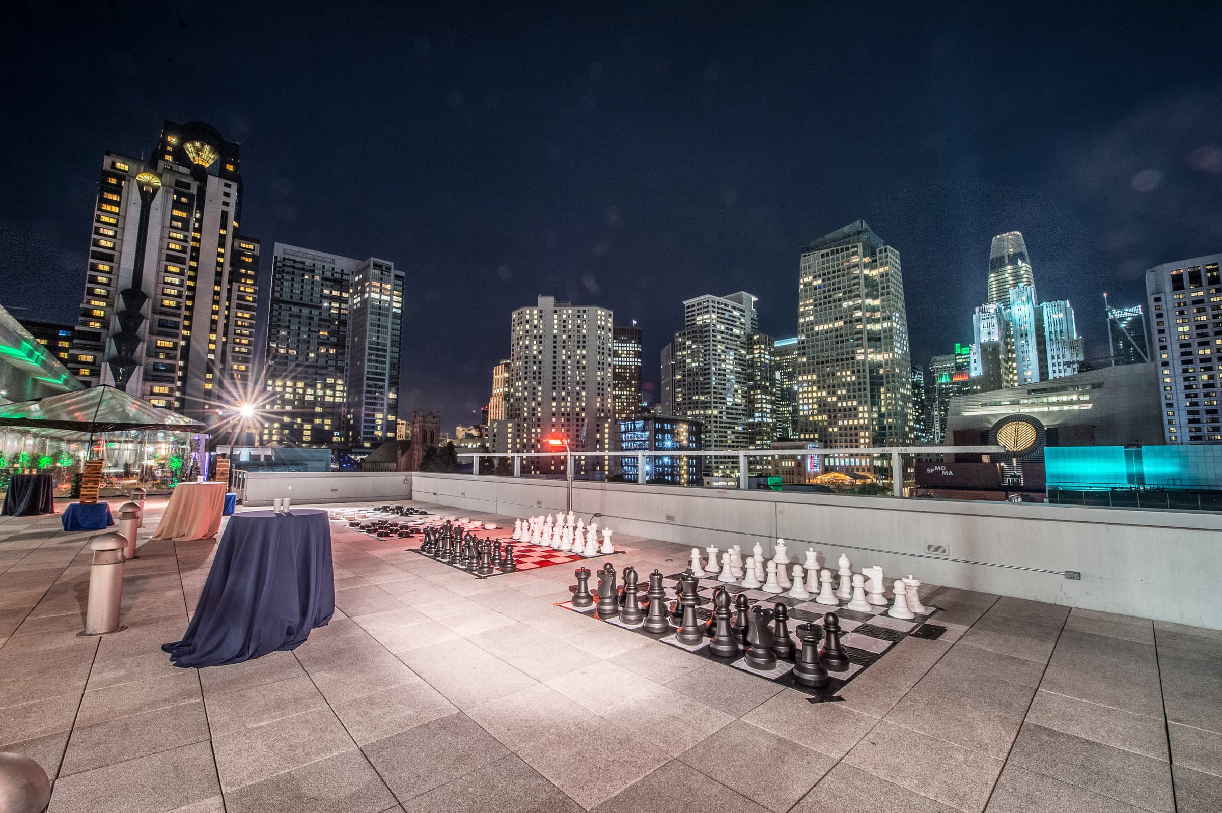 Rooftop terrace set for a reception with the city skyline at dusk