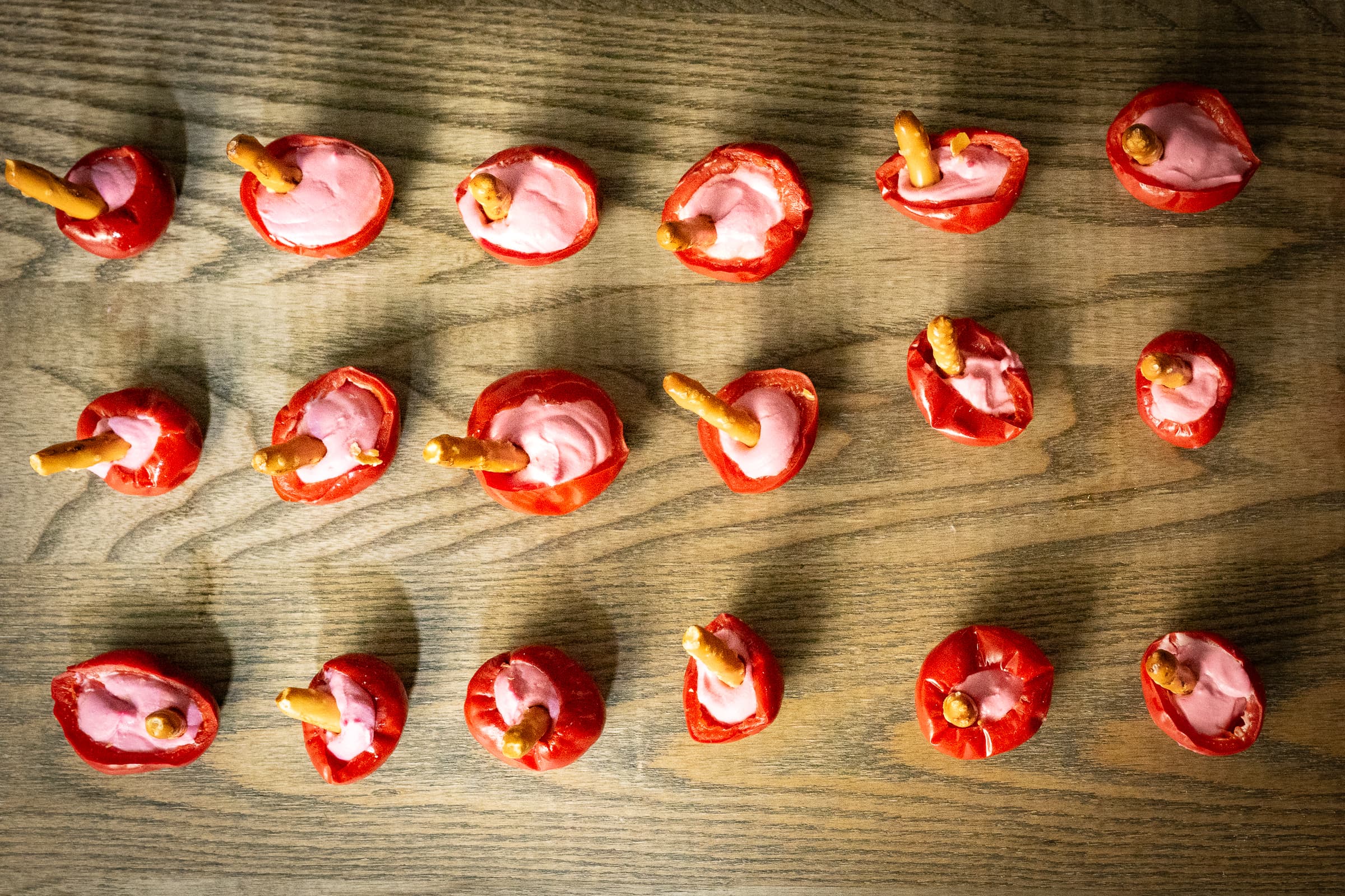 Rows of identical canapes plated across a wooden board