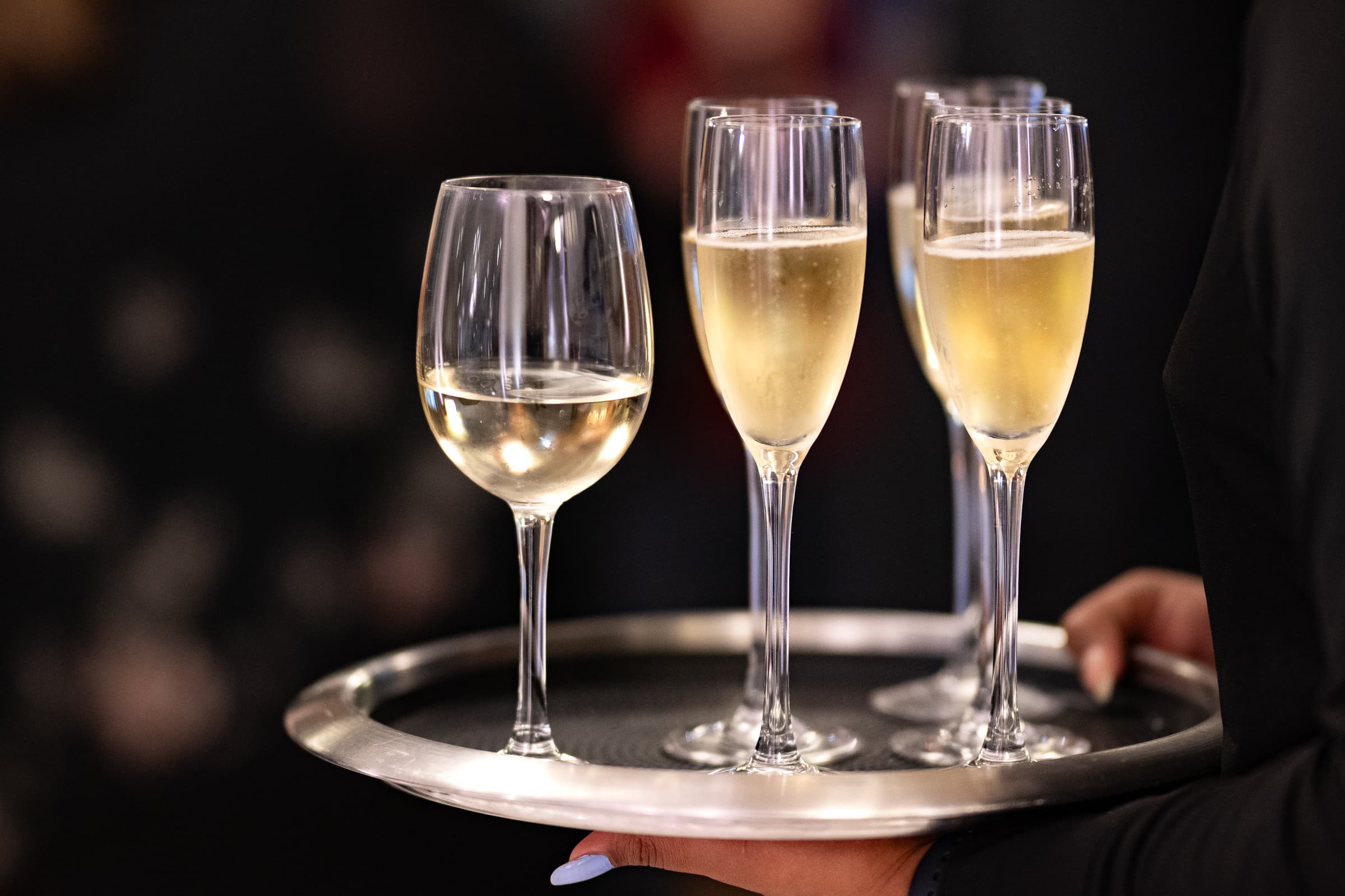 Tray of filled champagne flutes carried into service