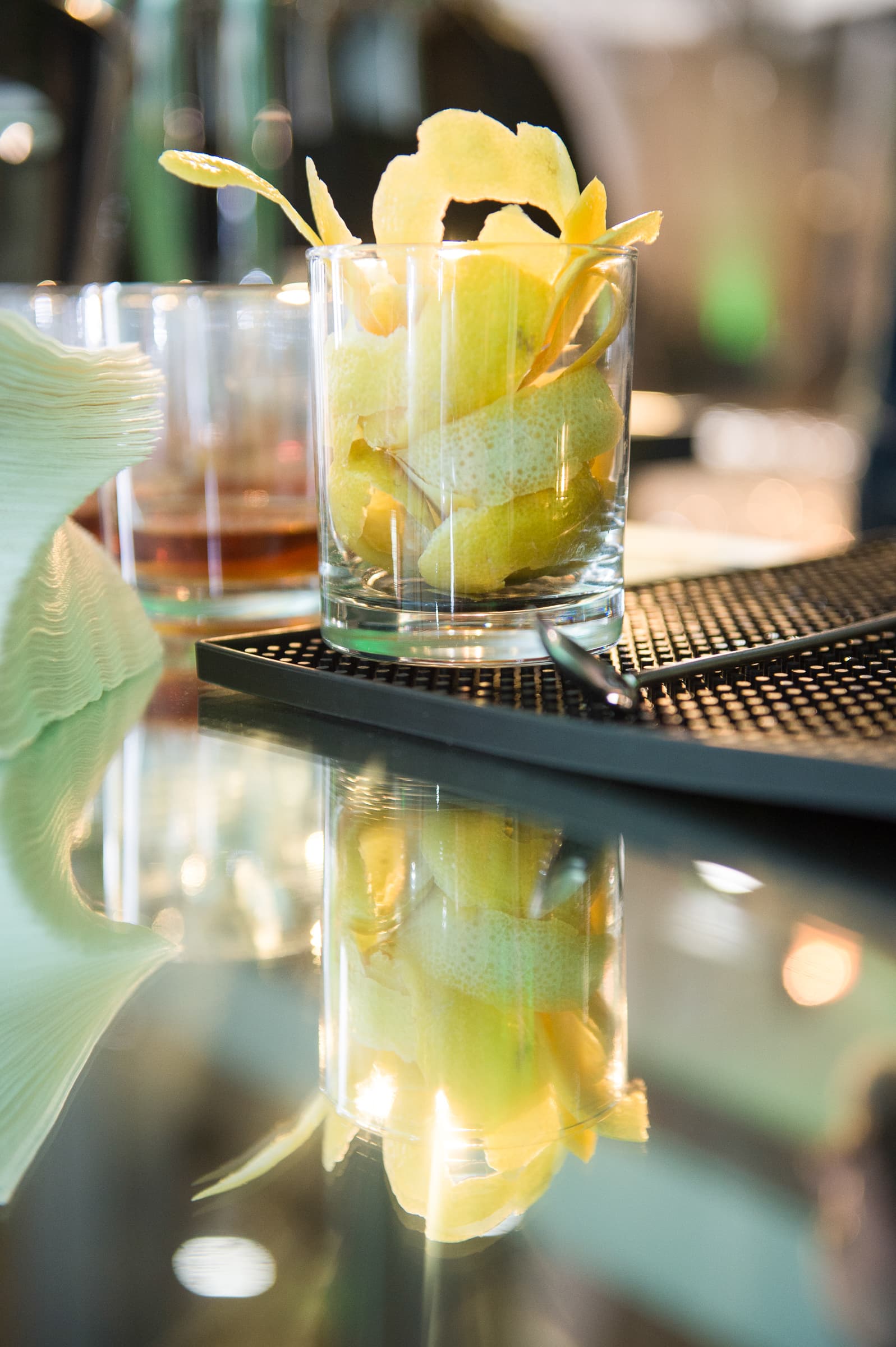 Garnished cocktail reflected on a polished bar top