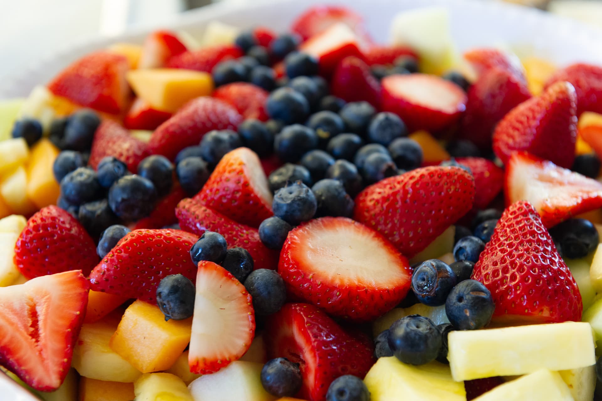 Colorful mixed fruit assortment with strawberries and blueberries on white background