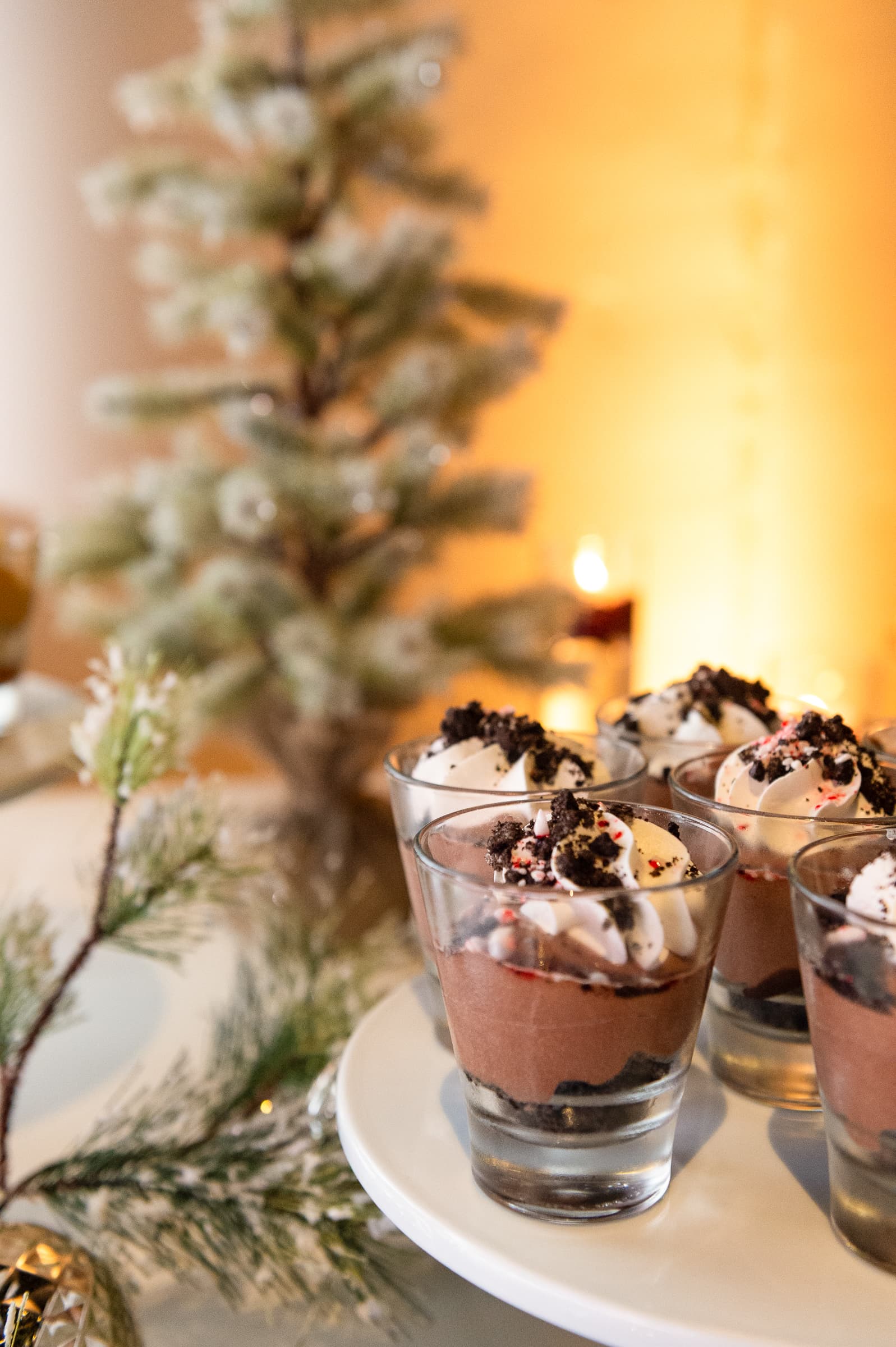 Individual dessert cups styled with winter greenery and warm candlelight