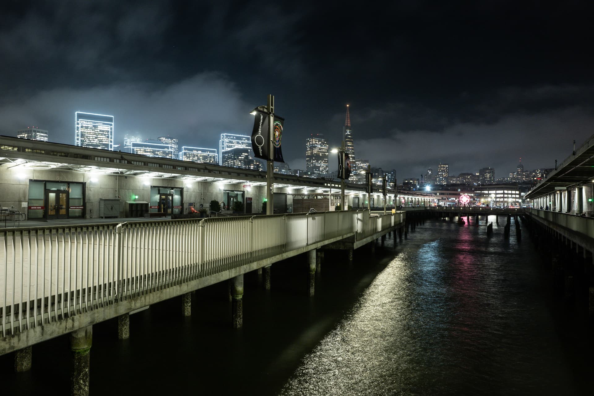 Exploratorium pier and waterfront beneath the illuminated San Francisco skyline at night