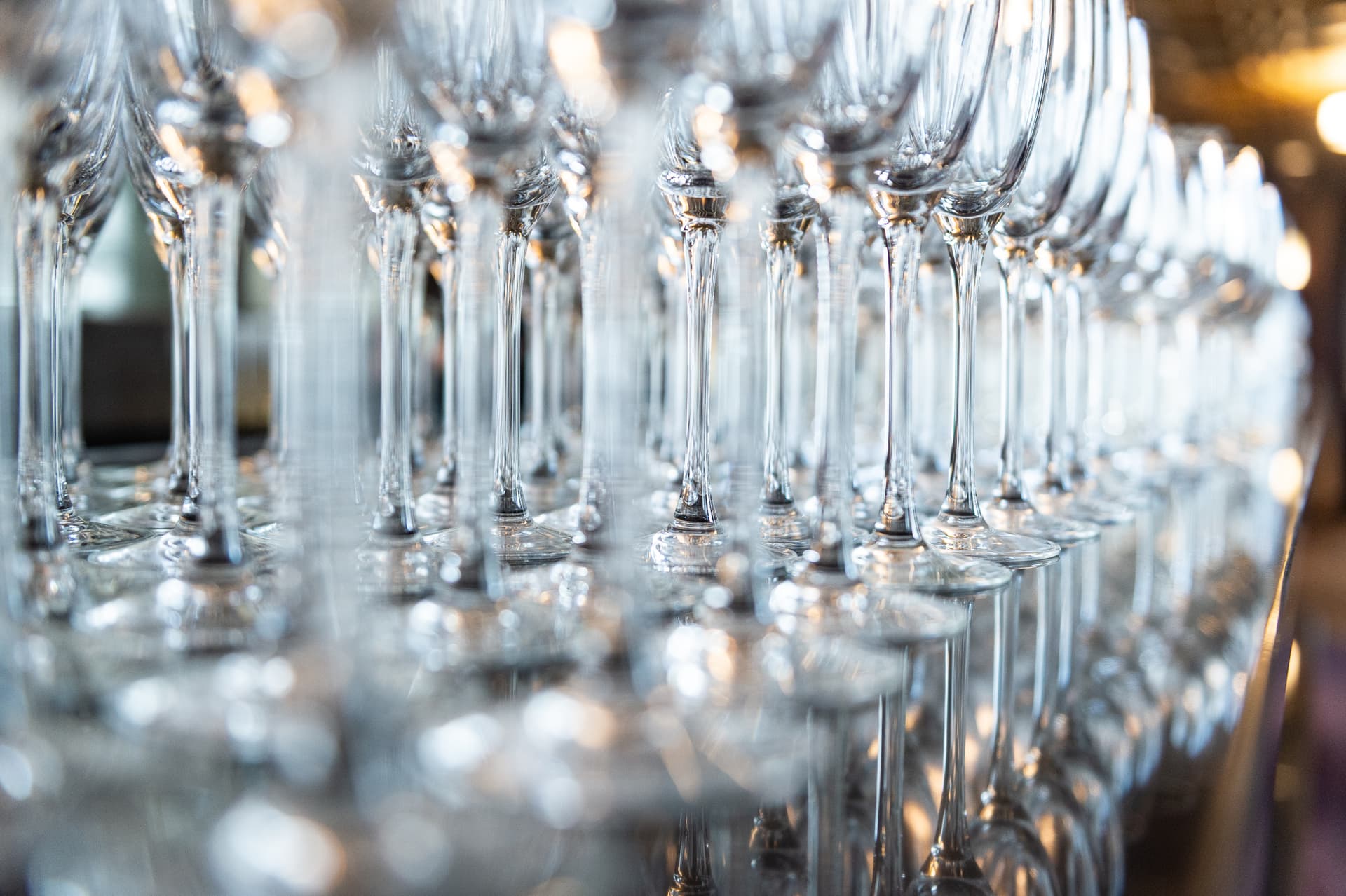 Close-up of rows of empty wine glasses reflecting light at the Julia Morgan Ballroom