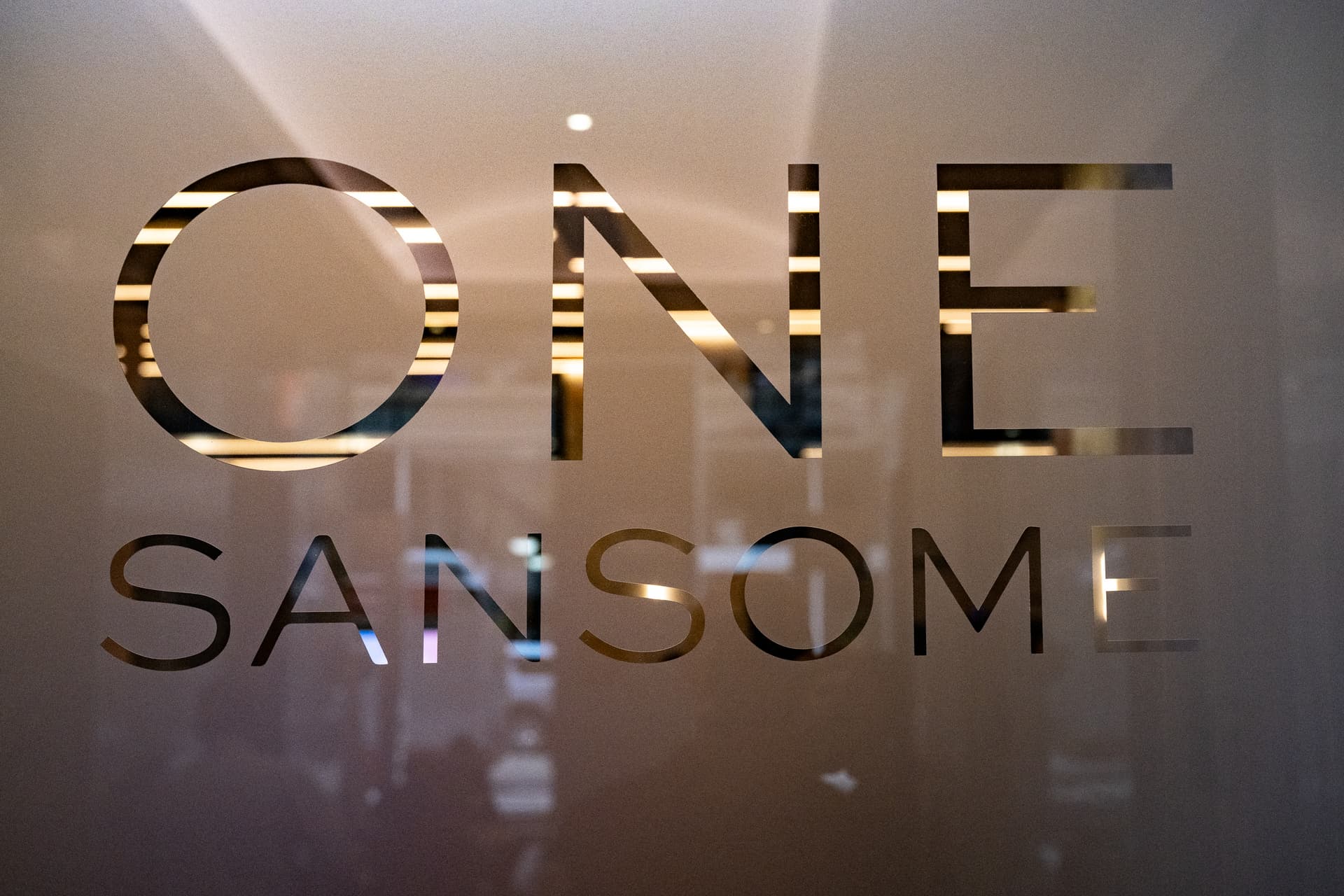 Reflective One Sansome lettering on a frosted glass entrance panel