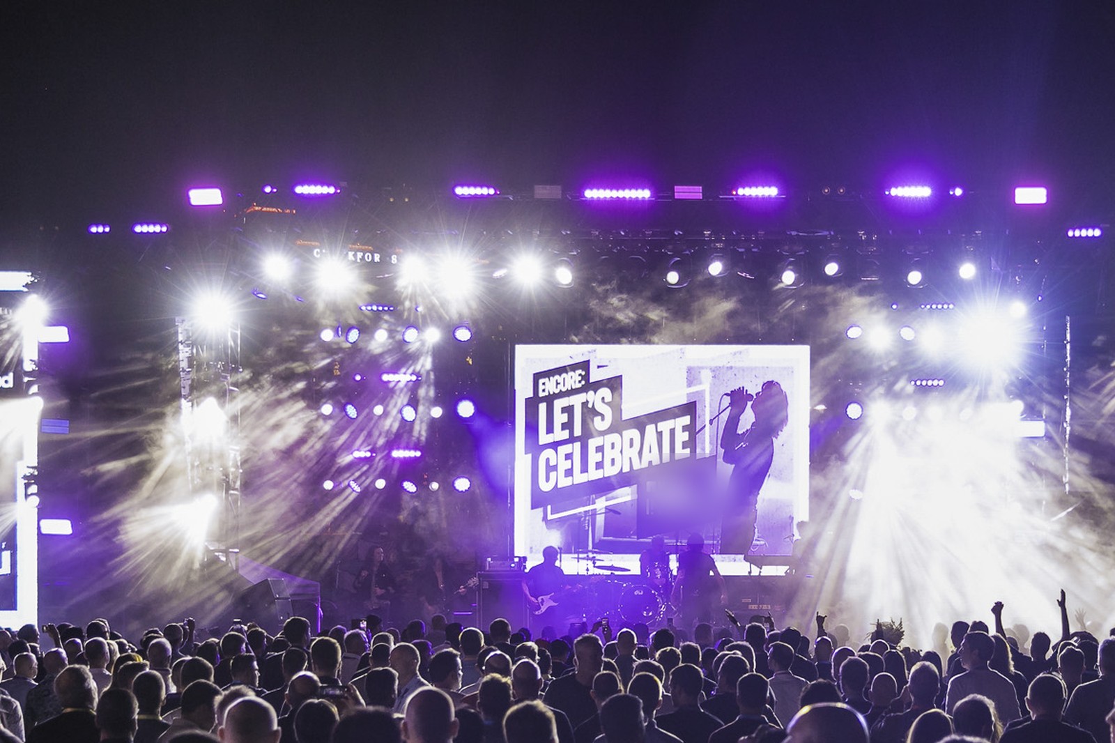 Evening concert at a corporate conference with stage lights sweeping over the crowd