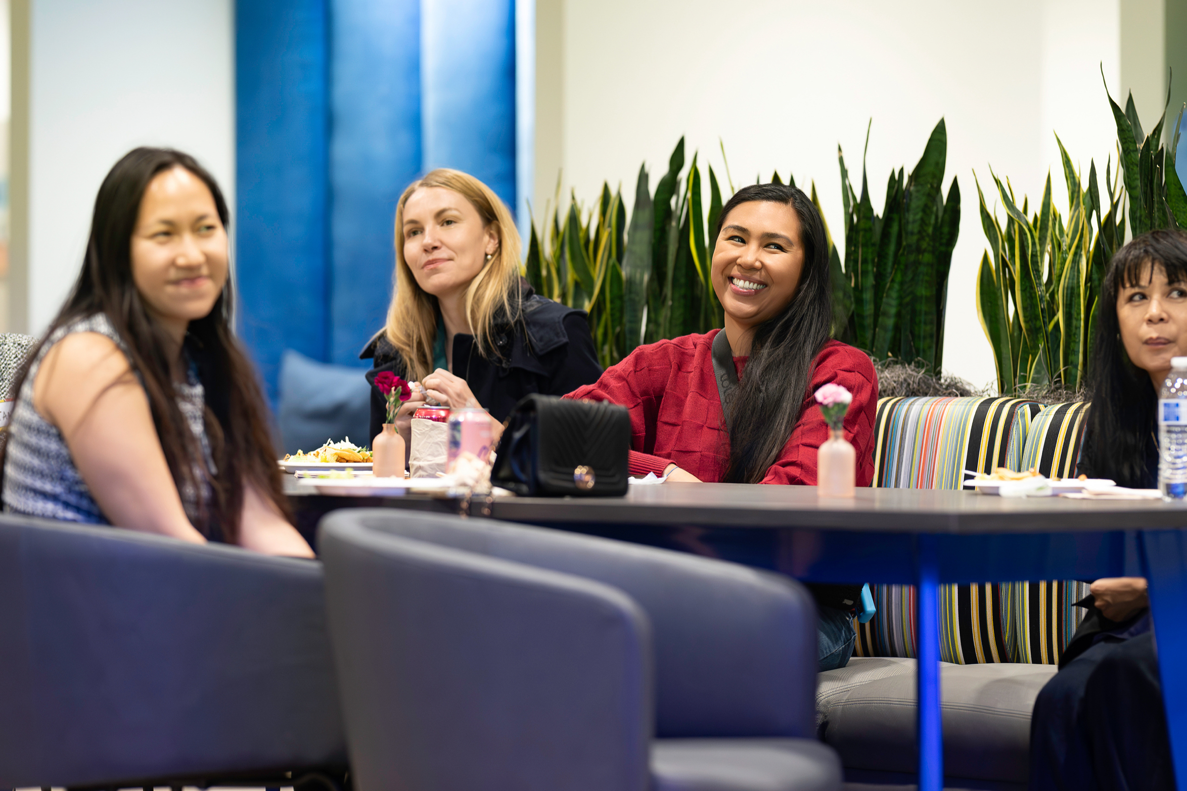 Attendees in conversation in a lounge area between sessions