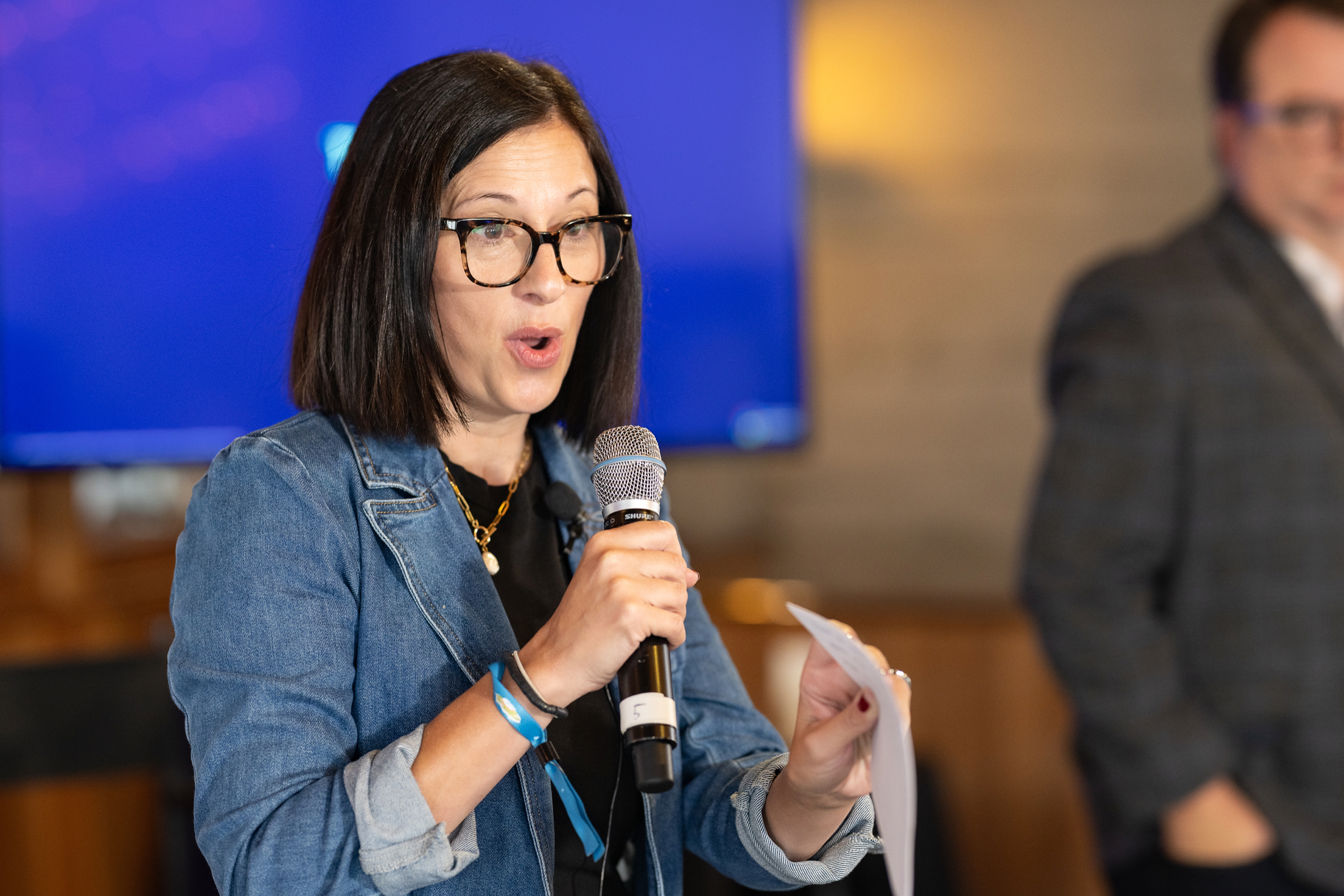 Guest asking a question with a handheld microphone during a hosted breakfast