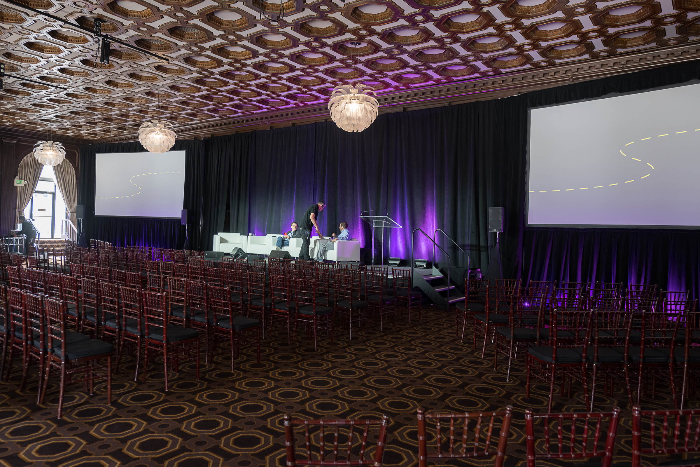 Empty ballroom set with a lit stage before a panel session opens