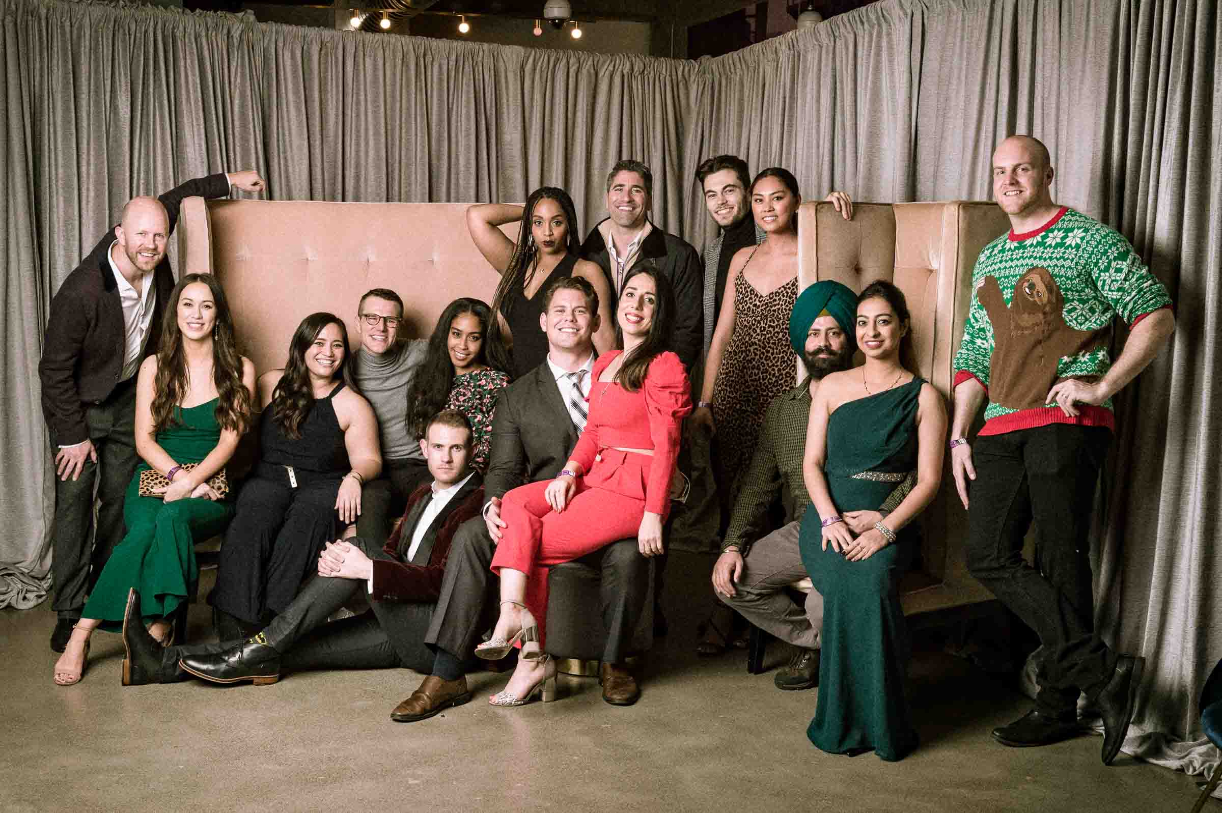 Formal group portrait of employees posed together on stage for holiday event