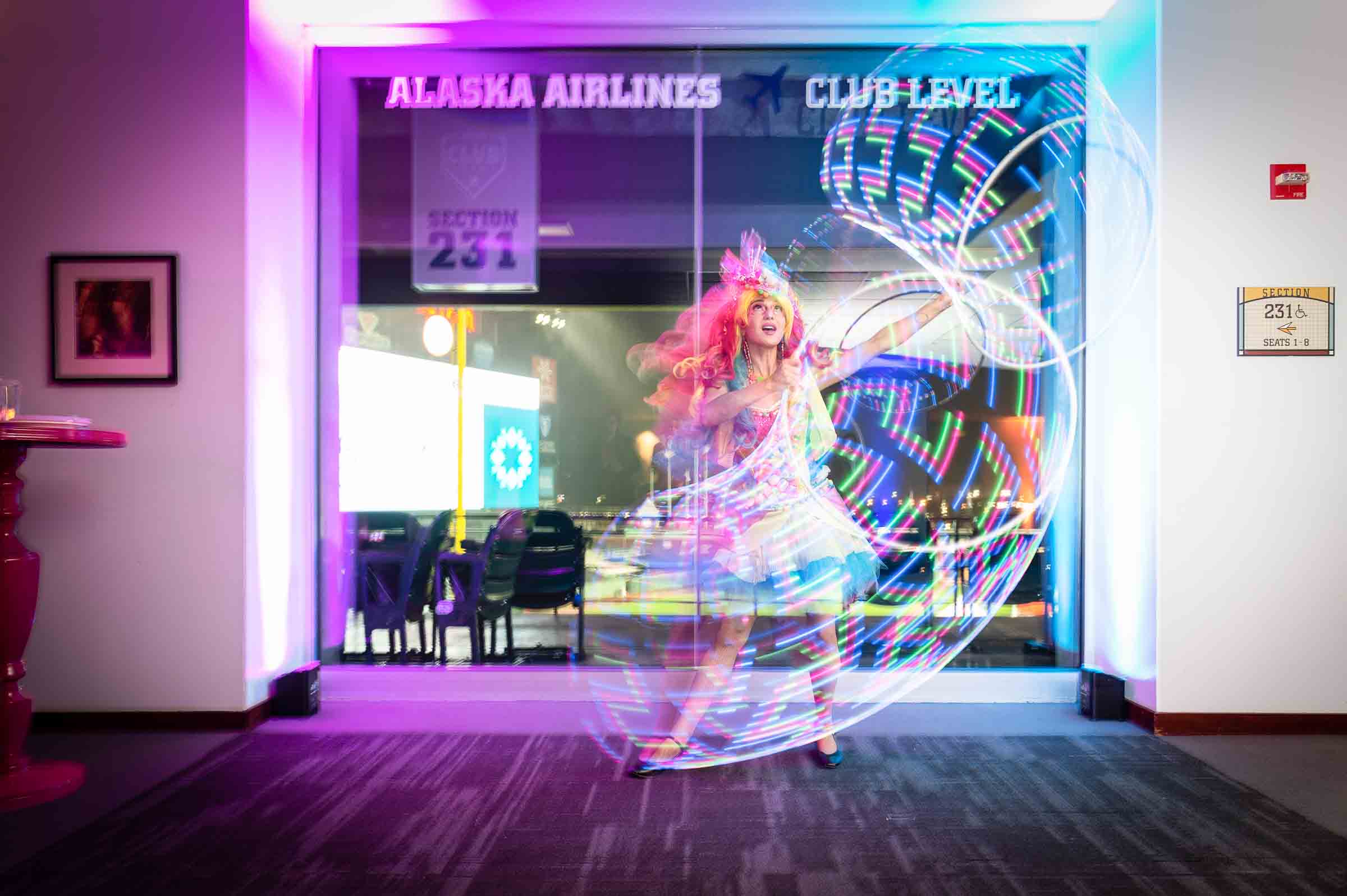 Person creating light painting effect with colorful illuminated neon spiral design