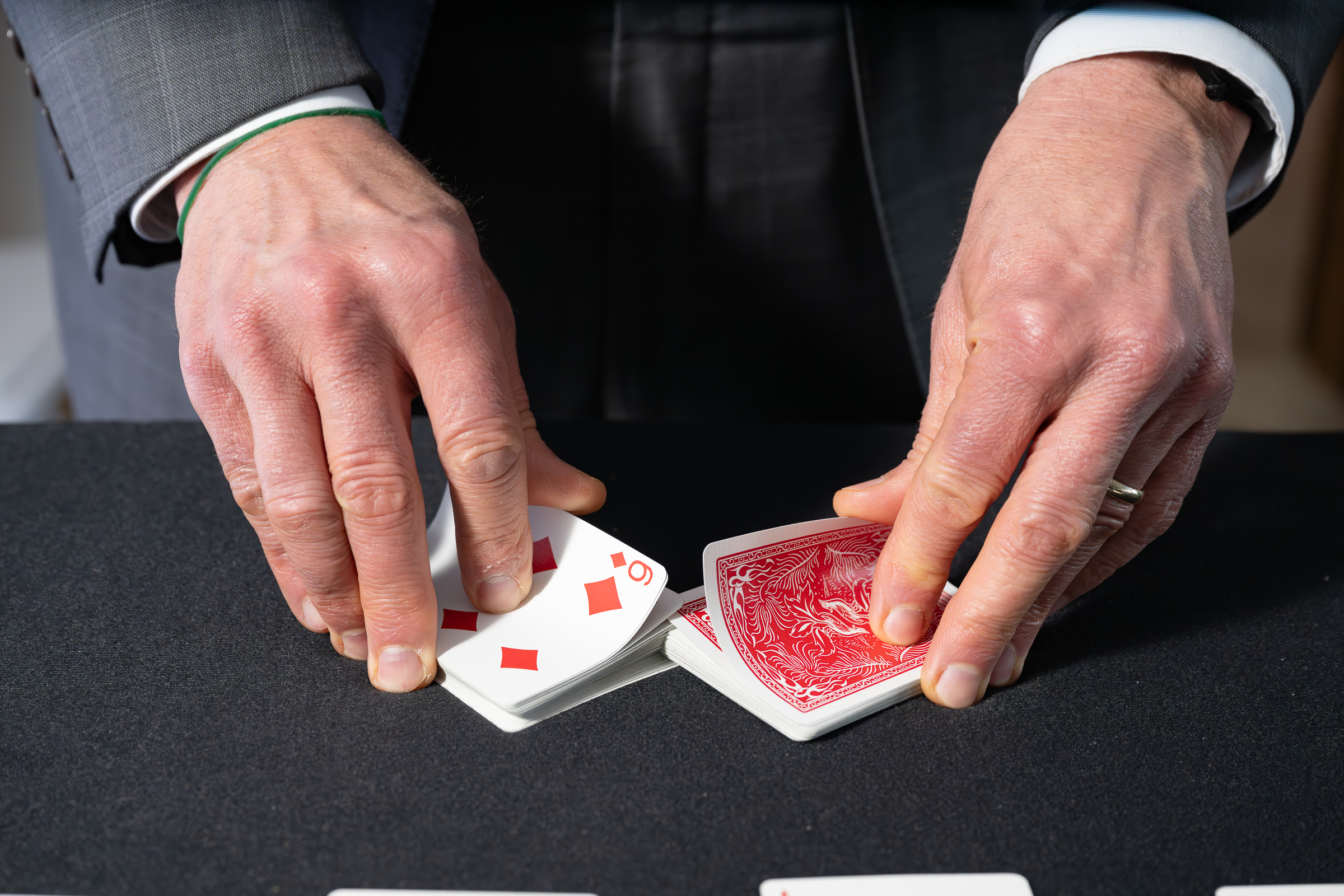 Close-up of a magician's hands performing a card trick during a reception