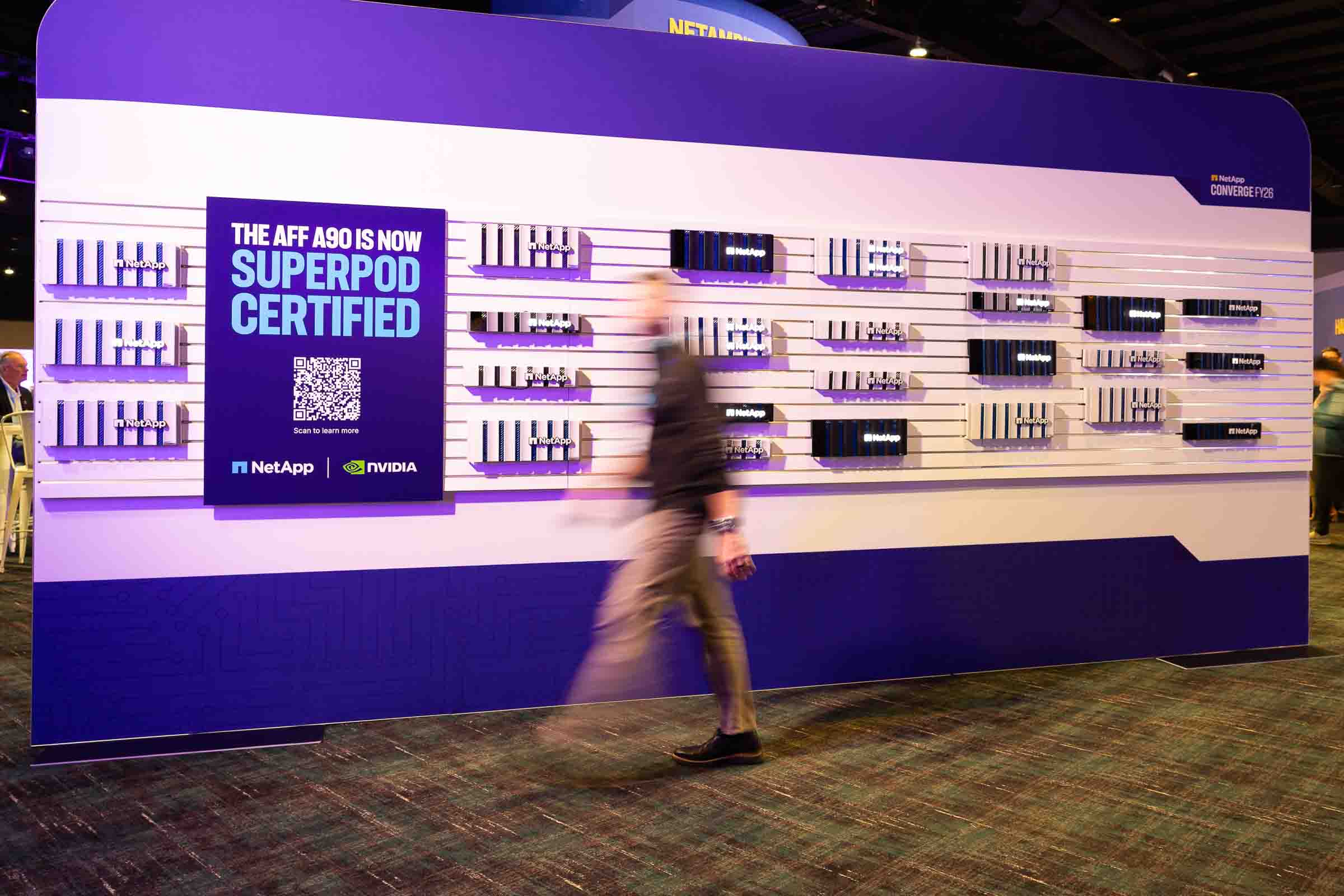 Large branded wall display with illuminated product shelving featuring purple and white accents
