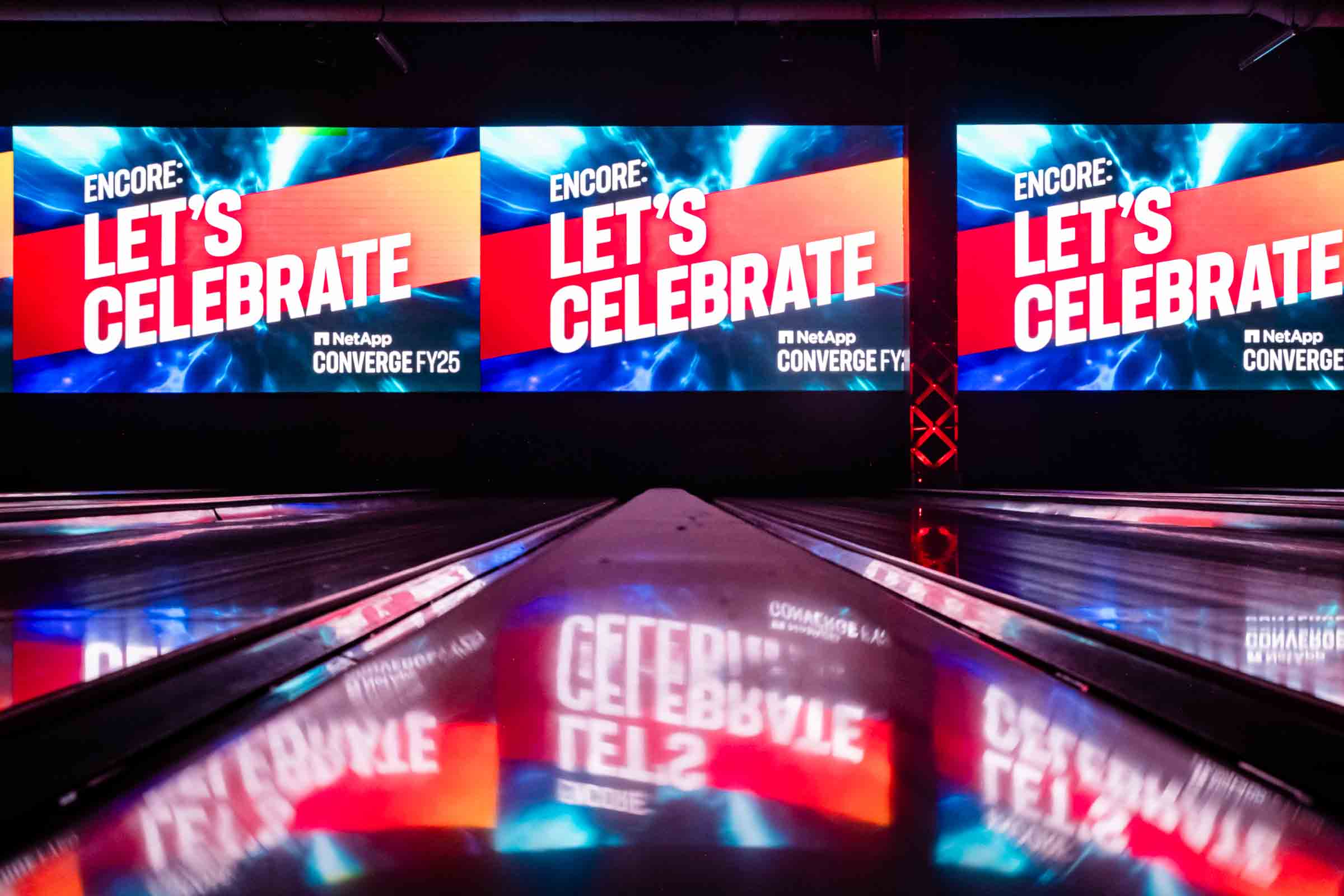 Dynamic conference stage with large branded screens and vibrant lighting installation