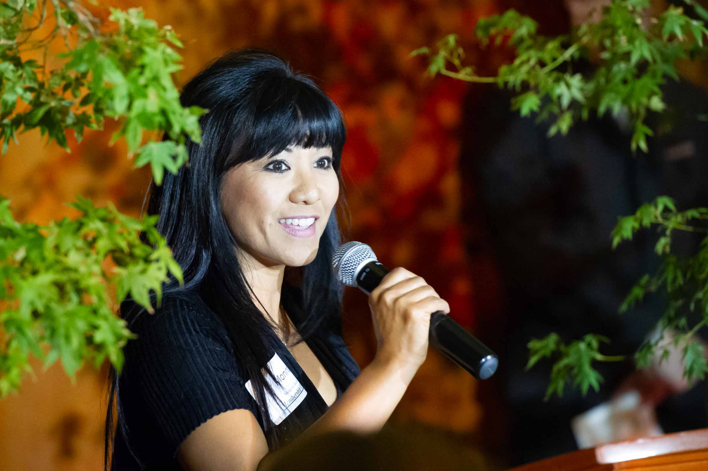 Woman in business attire speaking at podium with microphone during professional conference