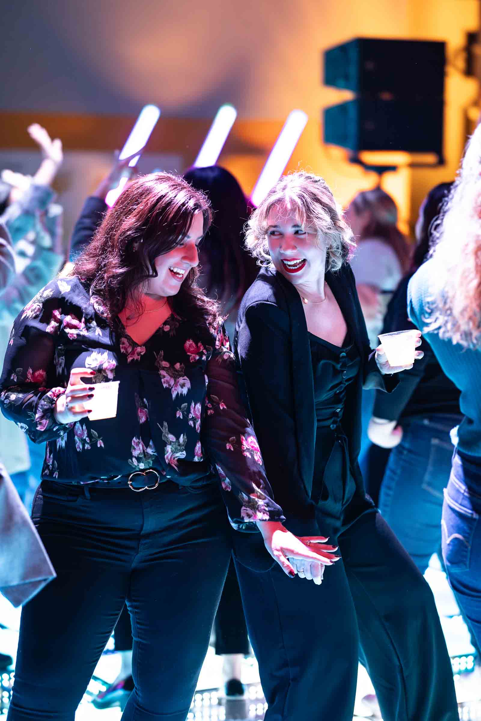 Guests enjoying cocktails and conversation with dramatic stage lighting behind them