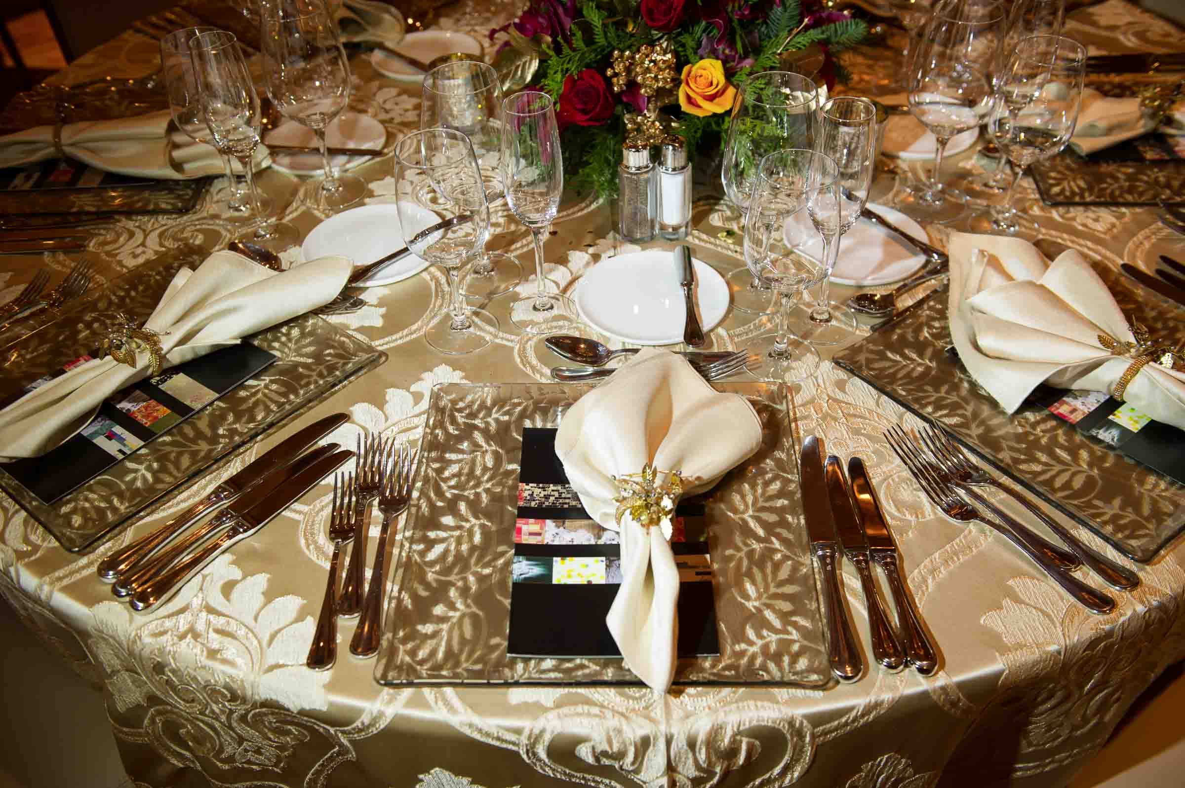 Elegant formal gala table with place settings, flowers, and gold damask linens