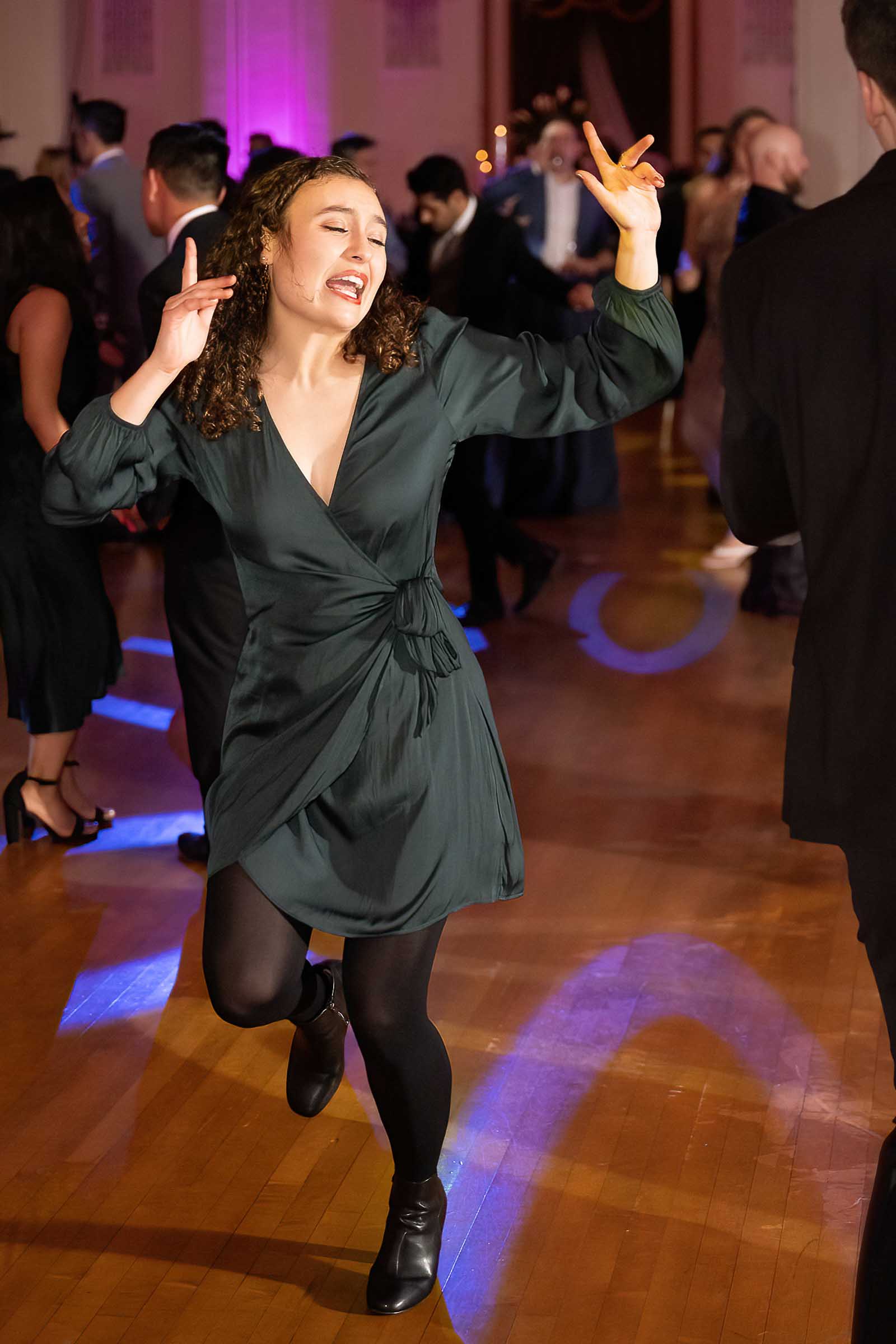 Woman dancing with expressive gesture on dance floor at formal gala event
