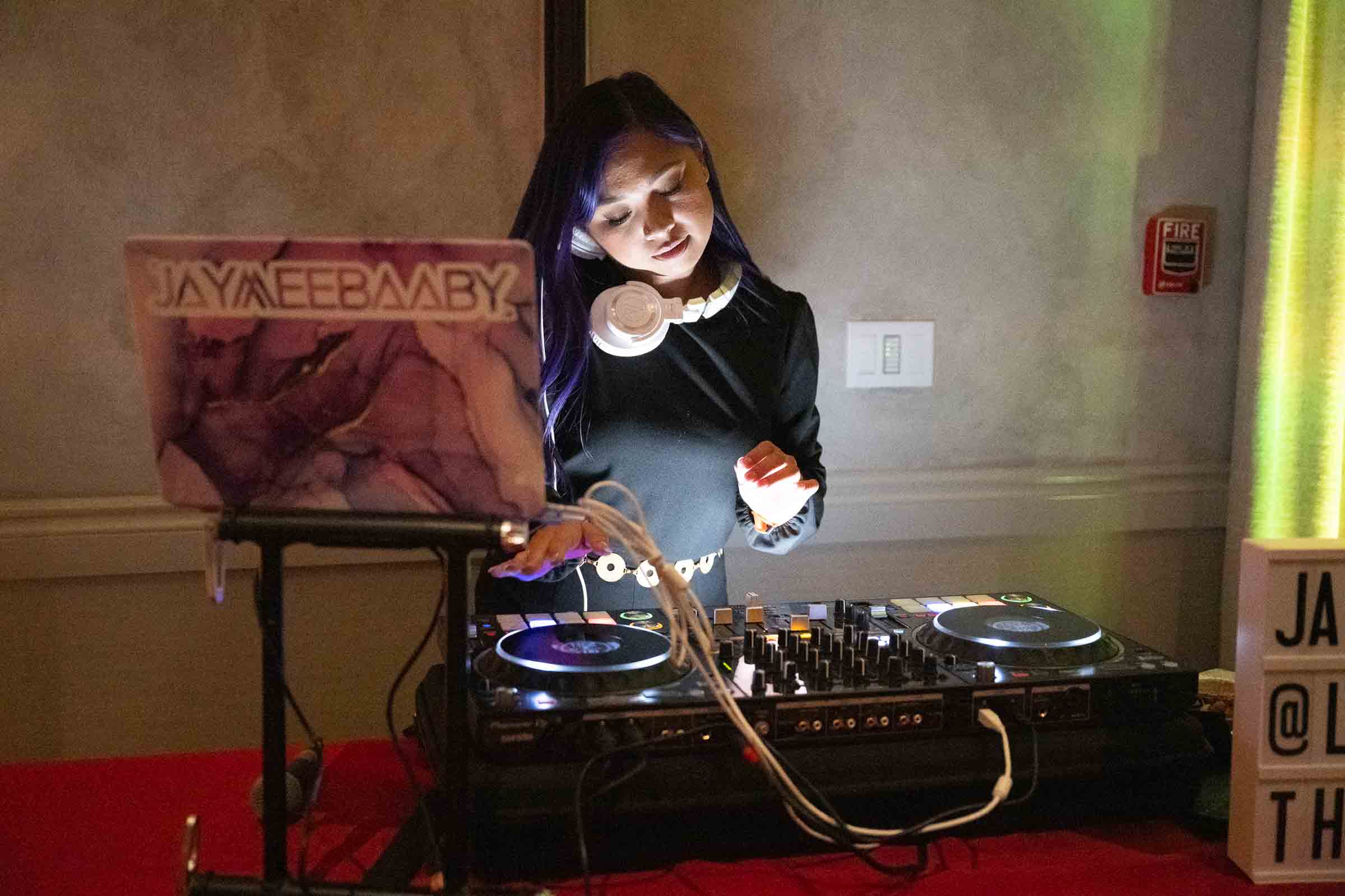 Well-dressed guests smiling and laughing while holding playing cards during social moment at formal dinner