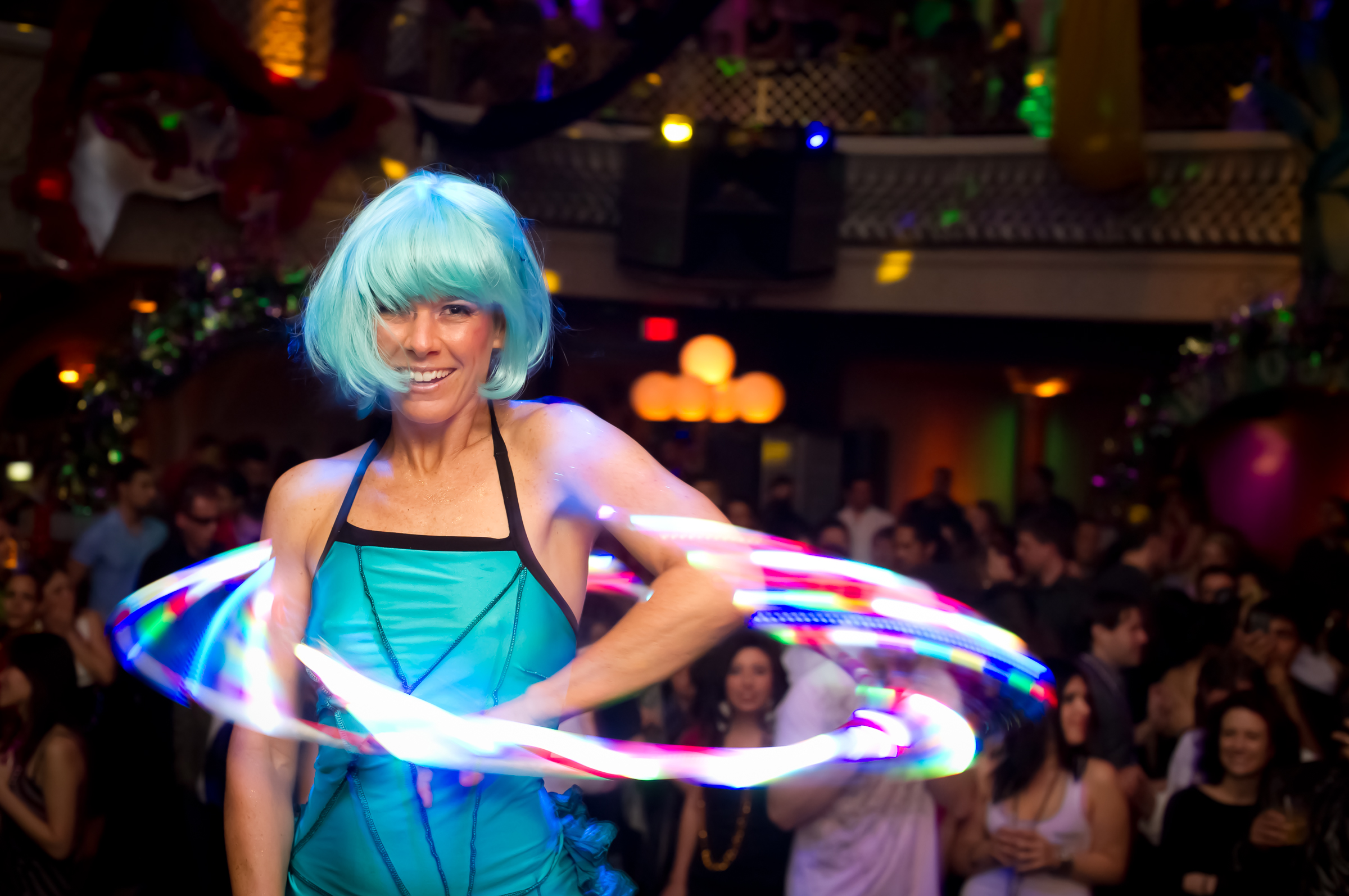 Performer with an illuminated hoop in front of gala guests