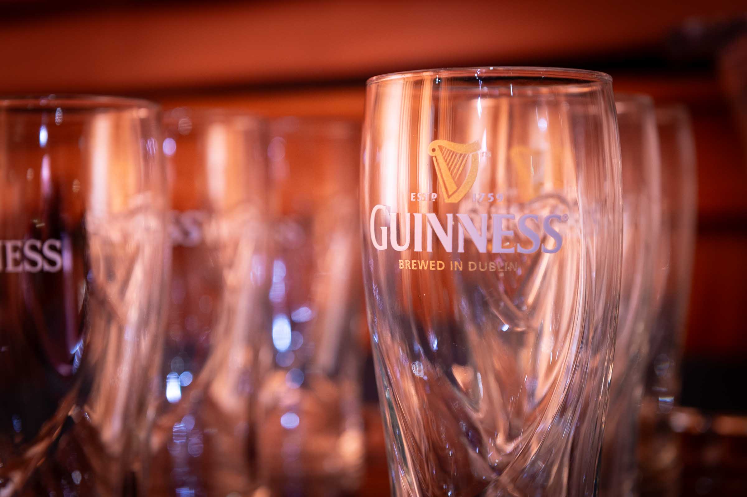 Close-up of branded whiskey glasses with warm amber liquid at elegant dinner event